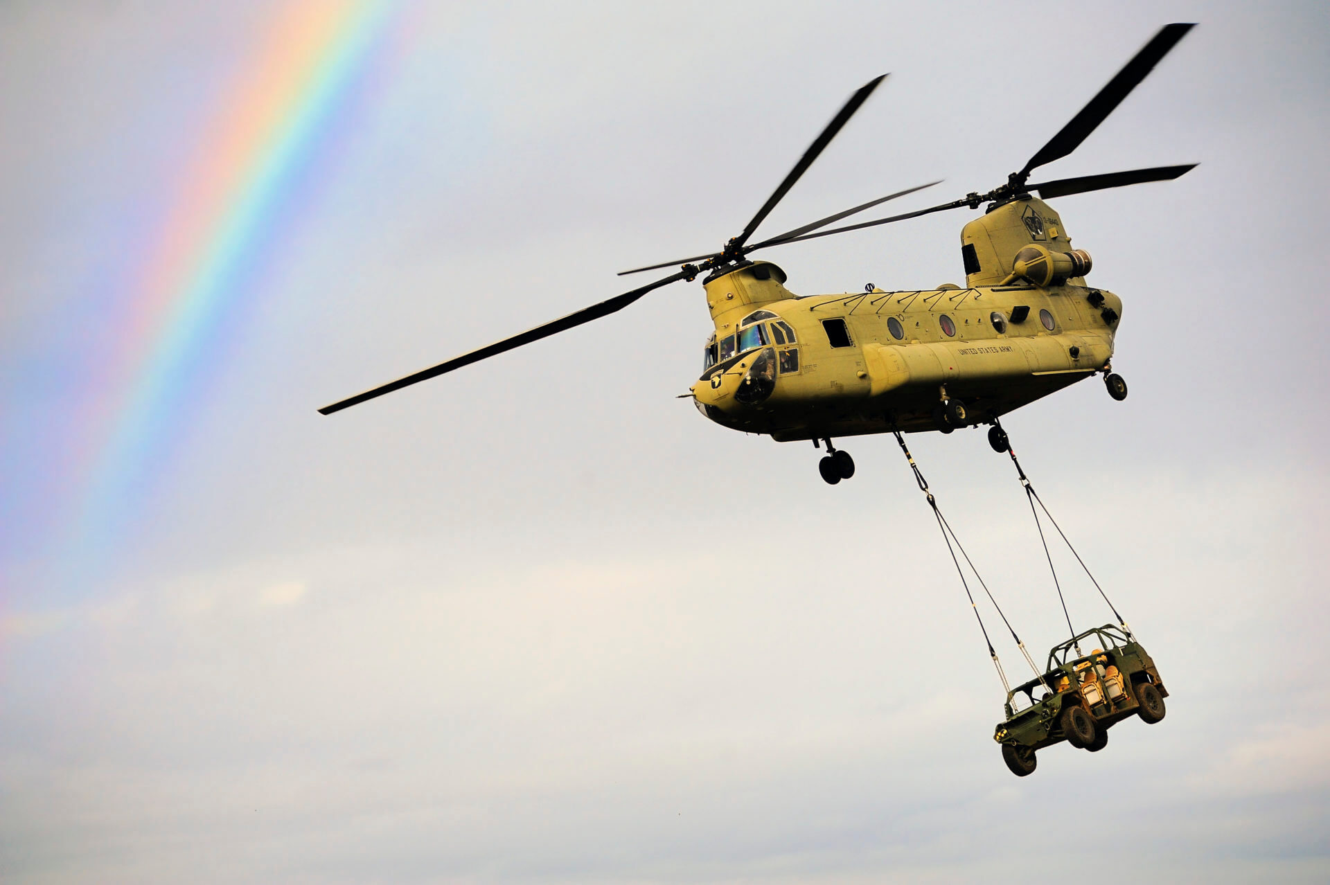 Header Image of Chinook Helicopter with sling load flying near rainbow