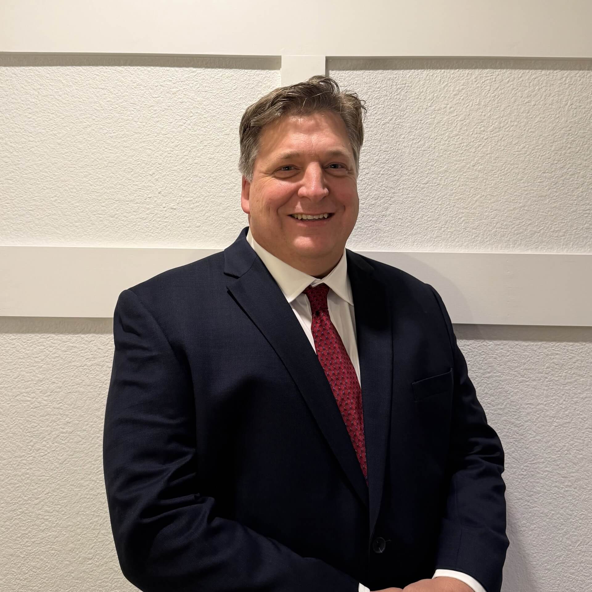 Mike Kunkel, in a white collared shirt and a blue sport coat