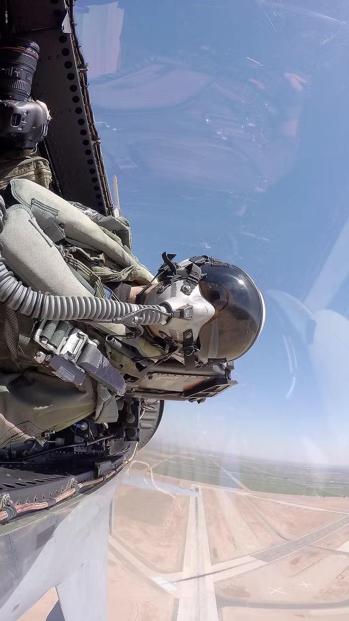 Scott Dworkin sitting in the back seat of an F/A-18 in a steep bank over an airport